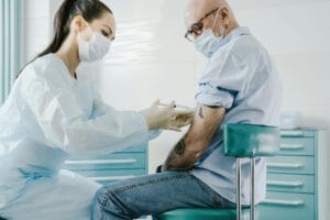 Healthcare professional giving a vaccine injection to a patient in a clinical setting.