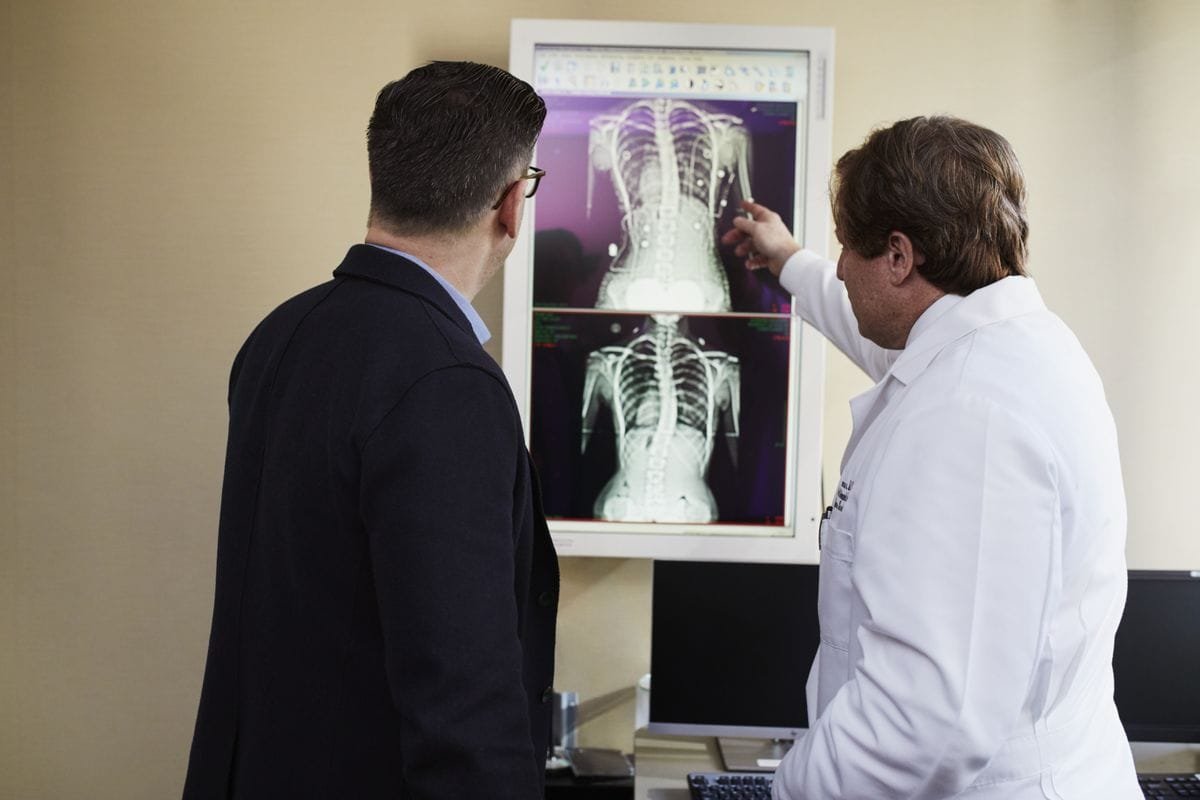 Doctor explaining spine scan results to patient, arthritis myths vs facts