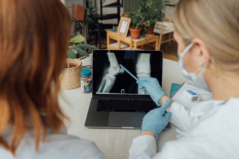 Doctor reviewing joint X-ray for gout vs rheumatoid arthritis diagnosis