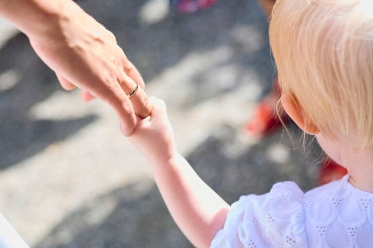 Parent holding child's hand, juvenile idiopathic arthritis care