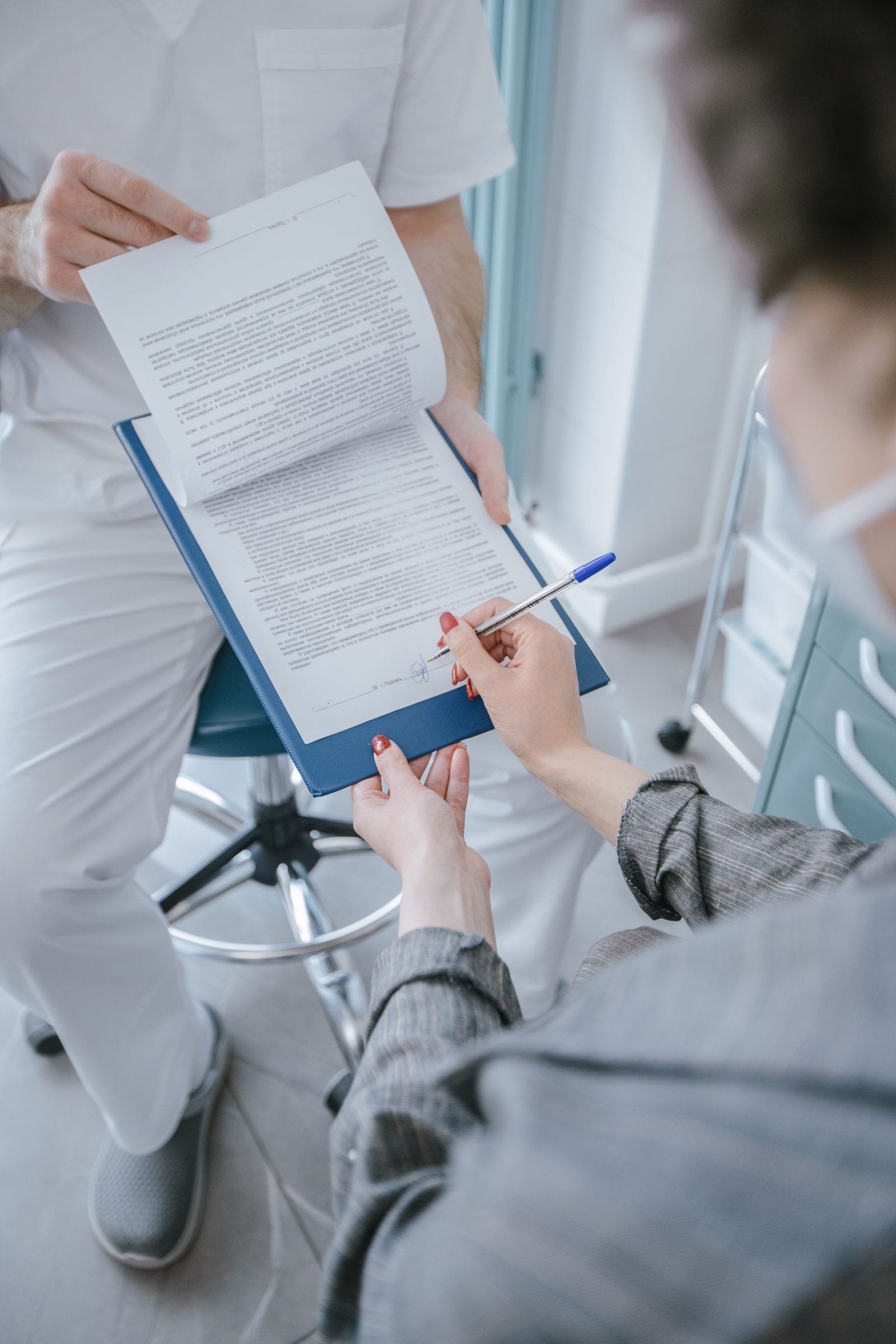 Patient signing a form at a doctor's clinic reception