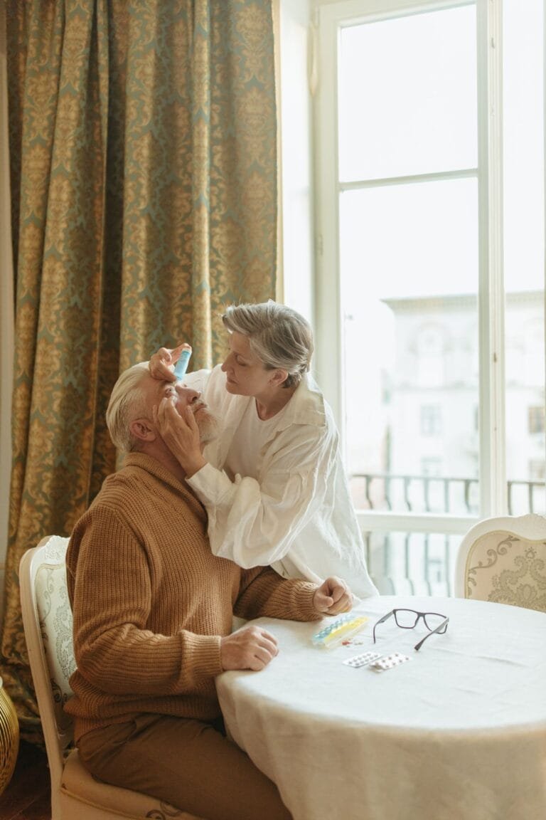 Applying eye drops for dry eyes, a common Sjogren's syndrome symptom