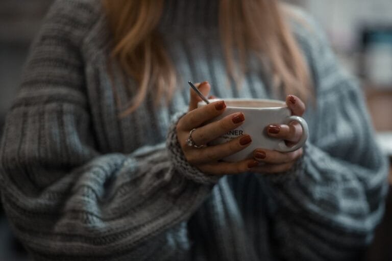 Hands wrapped around a warm mug in winter