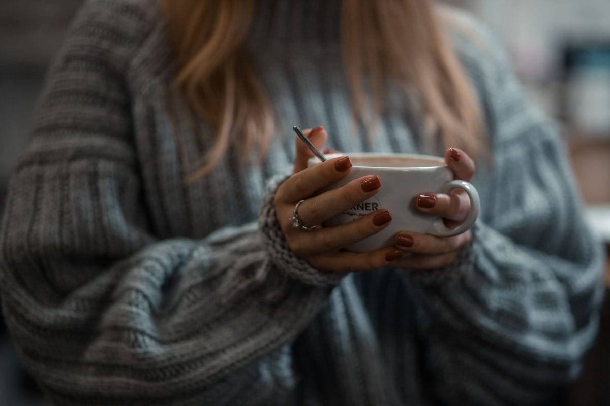 Hands wrapped around a warm mug in winter